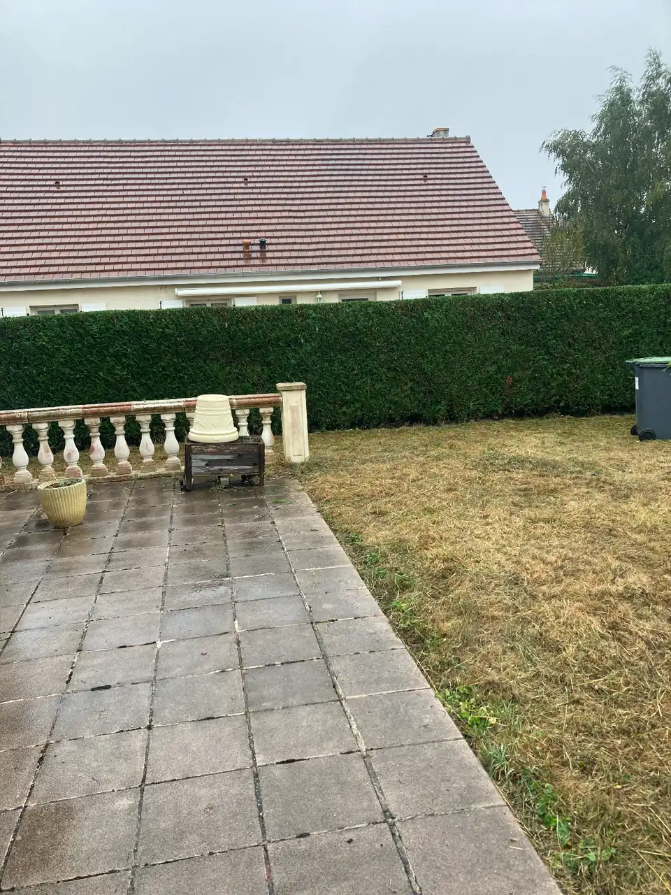 Pelouse tondue à côté d'une terrasse à balustres à Caen